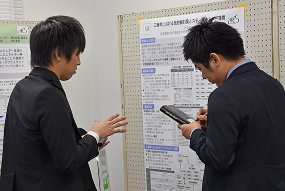 ポスター発表会場(環境創造部門)お客様の意見をメモをとる発表者