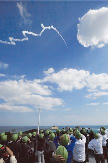 ロケットを地上から見つめる人たちの写真