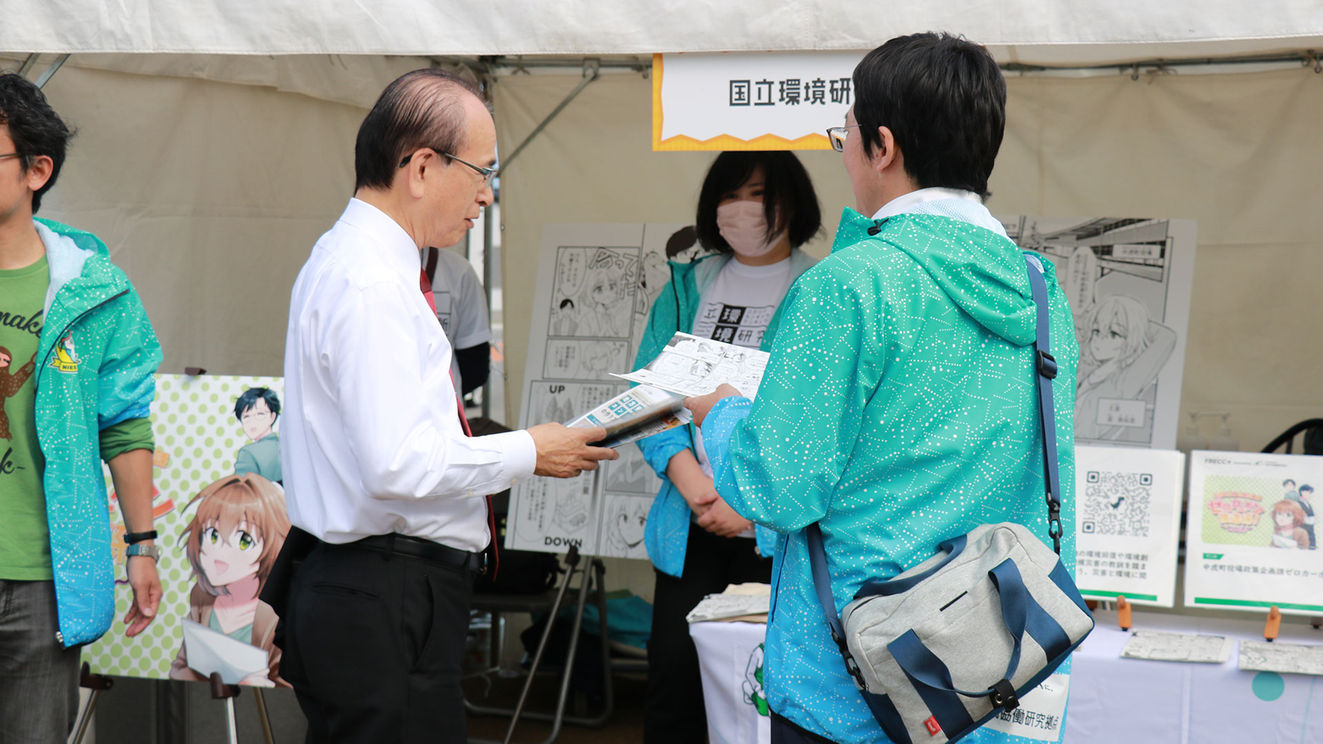 福島拠点制作マンガを見る大熊町長と五味室長