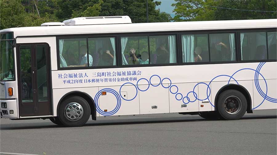 バスに乗って移動する子どもたち