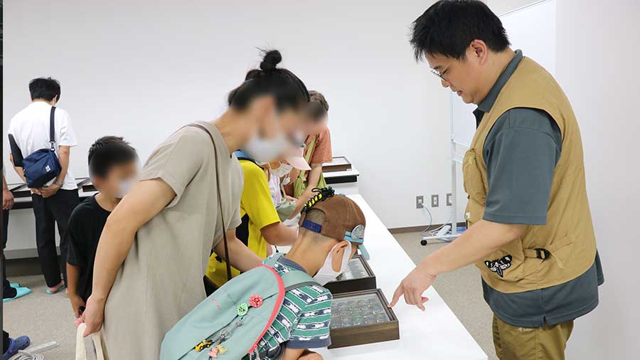 標本を観察する親子とJo高度技能専門員