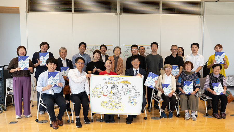 参加者全員の集合写真 中央にグラフィックレコーディング