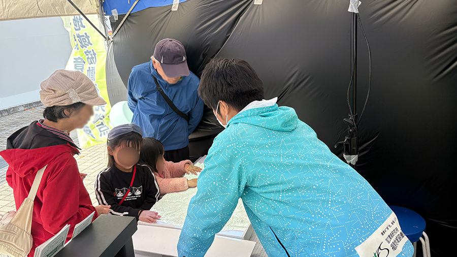 ３Dふくしまを見ながら説明を聞く家族の様子