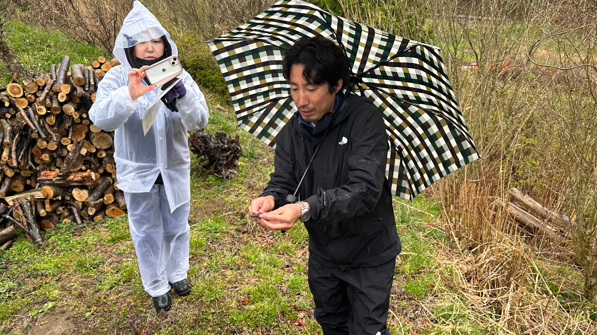 捕まえたカエルを見せながら説明をする境主任研究員