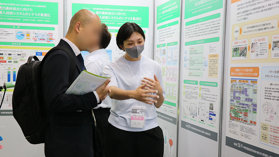 来場者に説明を行う三成研究員