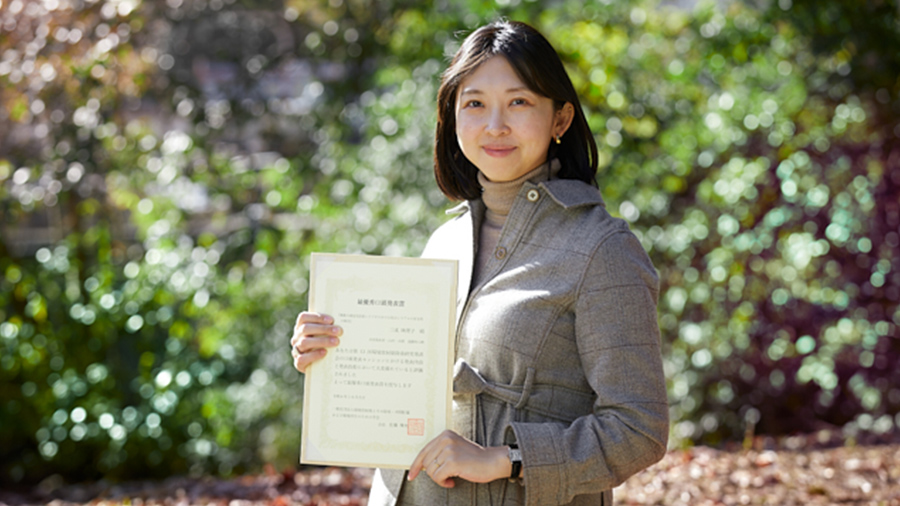 賞状を持つ三成研究員