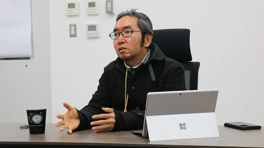 インタビューにこたえる中村主任研究員