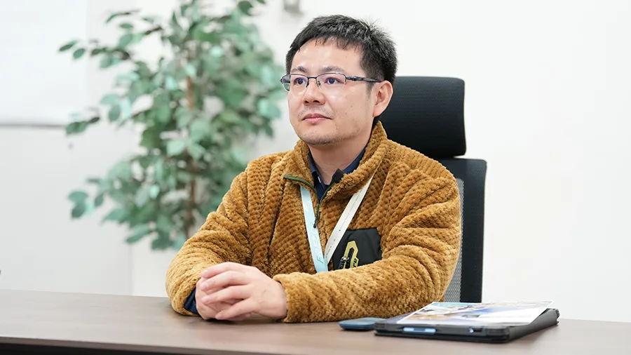 インタビューにこたえる吉岡主幹研究員