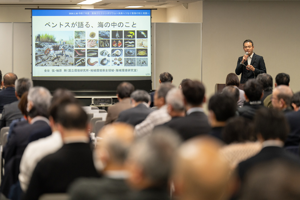 たくさんの聴衆に向けて研究の説明をする研究員
