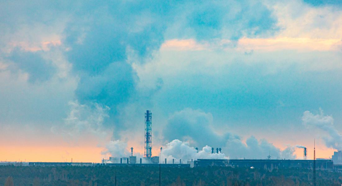 Smoke is rising from the chimneys of the giant plant leading to environmental pollution