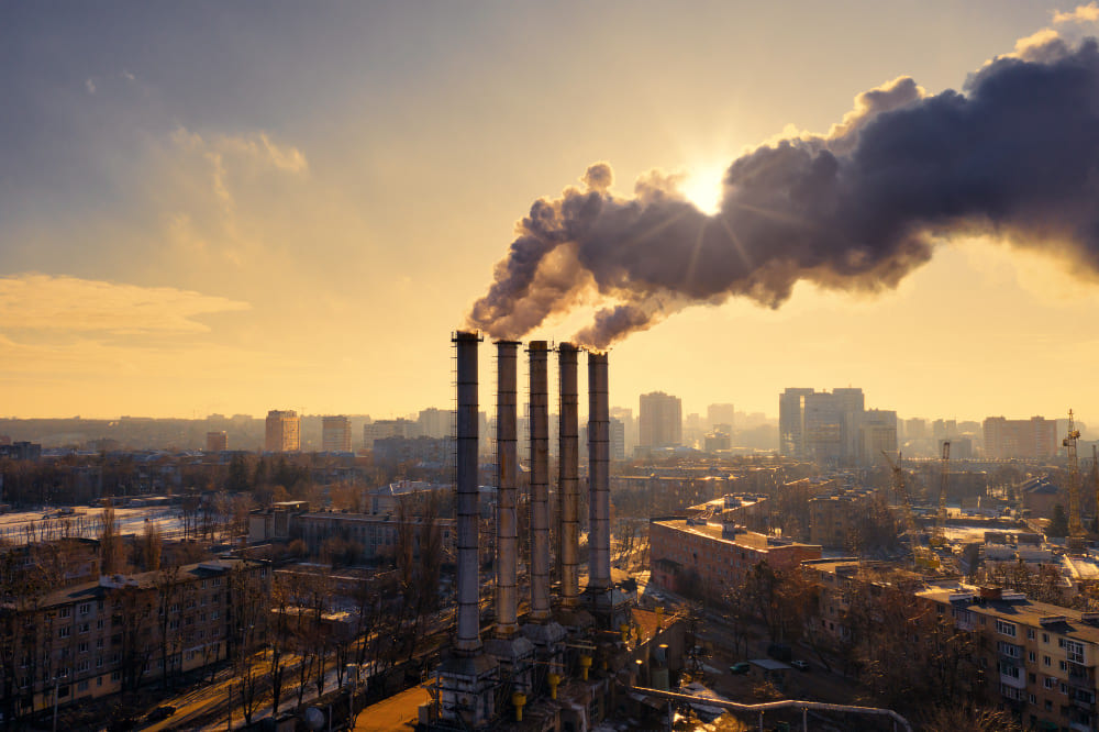 Gray smoke billowing from many chimneys in an industrial area