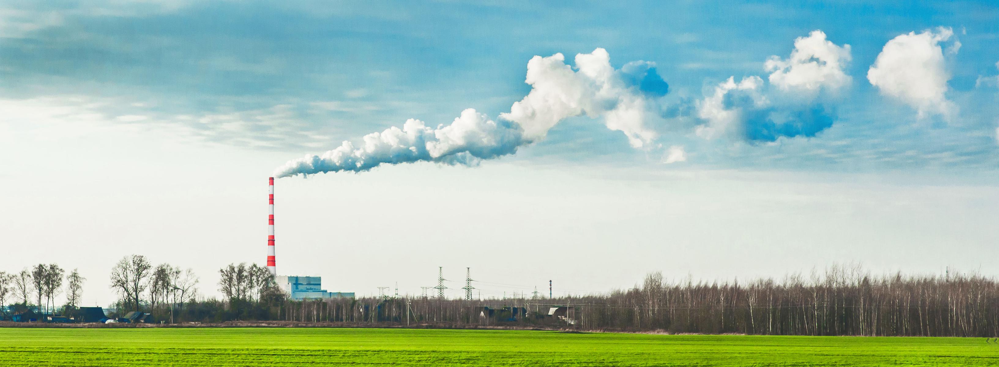 工場から有毒ガスを含む煙が空に流れていっている外国の風景